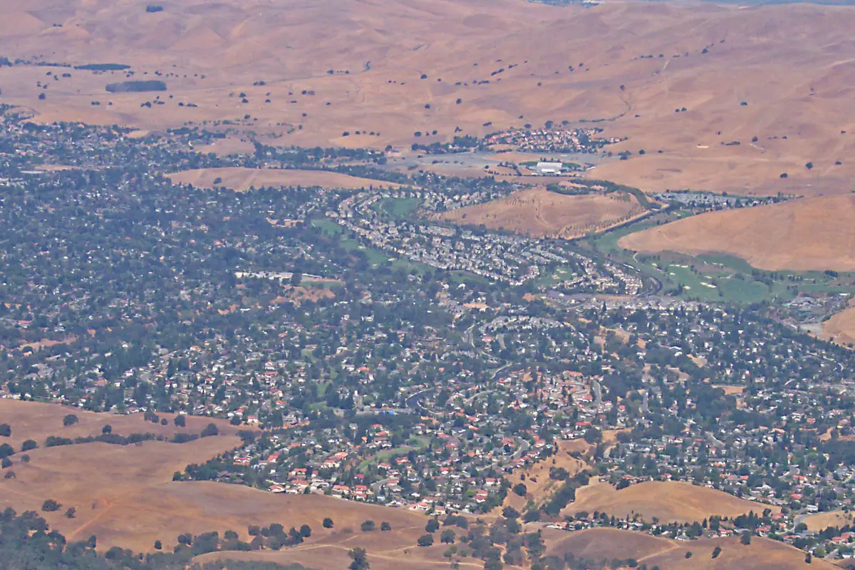Aerial view of Clayton neighborhoods against golden hills